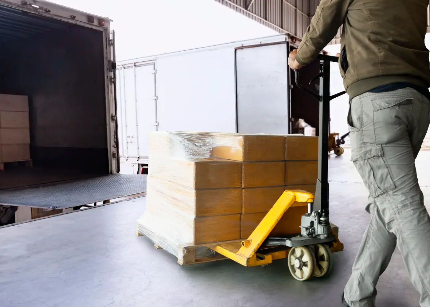 Warehouse team unloading palletized cargo from a delivery truck